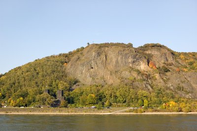 Erpeler Ley und Überreste der ehemaligen Ludendorffbrücke in Erpel, von Remagen aus gesehen; große Teile des Bergs (v.a. offene Felsbereiche) im Naturschutzgebiet „Erpeler Ley“